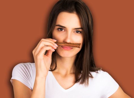 cinnamon concept girl holding and smelling cinnamon stick