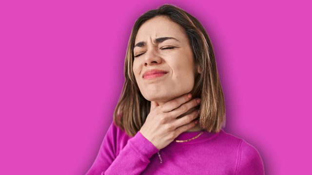 Hispanic woman standing over pink background touching painful neck, sore throat for flu, clod and infection