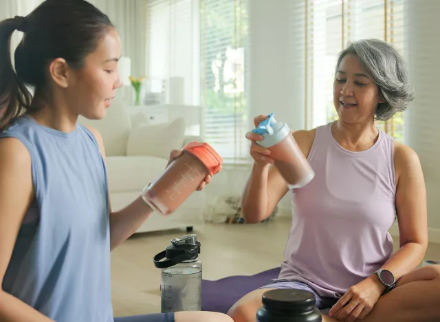 Young adult child active mature middle age old mum drink whey protein shake bottle diet food after home workout. Love health care older aged mom asia elder people happy relax sport protect aging life.