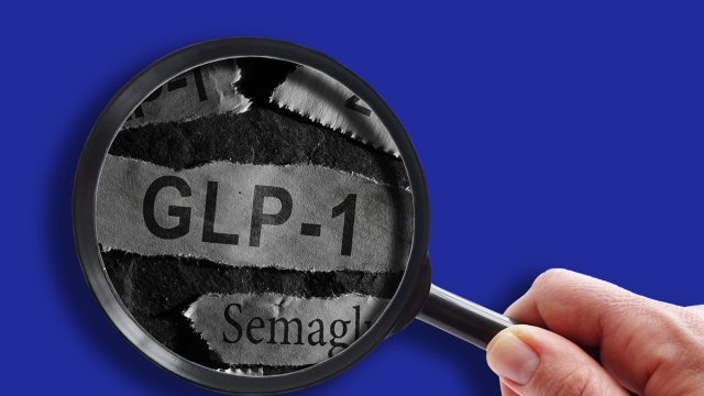 Raleigh, NC - USA - 06-13-2024: GLP-1 related drugs newspaper headlines with hand and magnifying glass