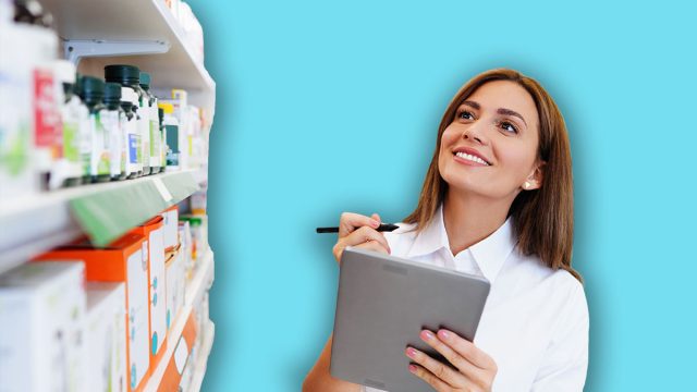 Beautiful pharmacist working and standing in a drug store and doing a stock take. Portrait of a positive healthcare worker or a chemist at his work.