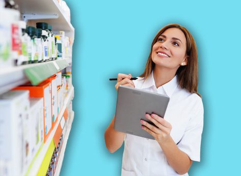 Beautiful pharmacist working and standing in a drug store and doing a stock take. Portrait of a positive healthcare worker or a chemist at his work.