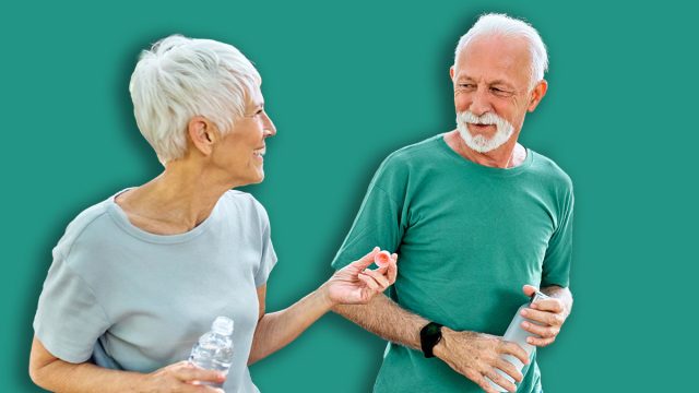 Smiling active senior couple jogging exercising and having fun and laughing together taking and walking a break in the park