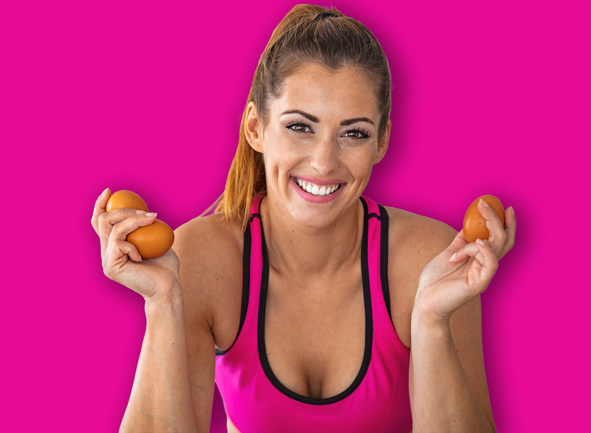 Young beautiful woman holding fresh egg at home with surprise face. Woman taking eggs. Beautiful young woman showing egg with happy face. Healthy homemade oatmeal