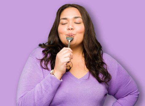Relaxed attractive hispanic woman closing her eyes while eating delicious dessert with a spoon