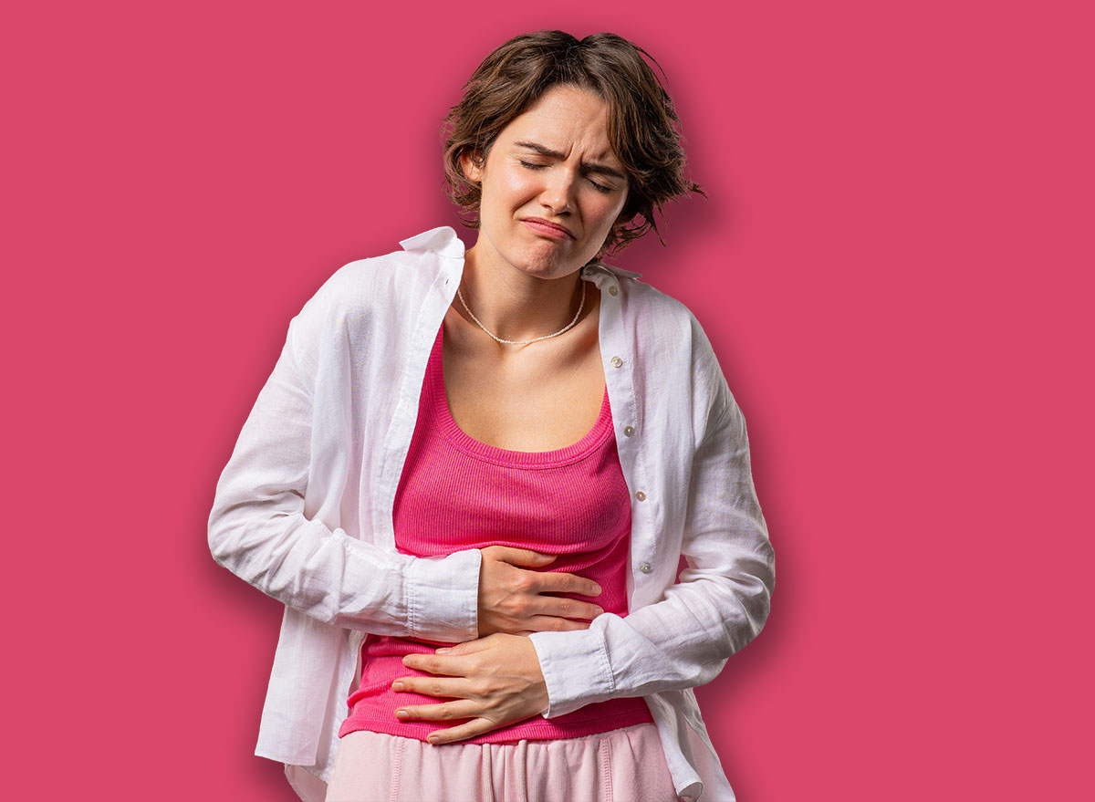 American woman squeezing belly with hands because of abdominal pain. Lady suffering from stomach ache. Healthcare, problem with menstrual period cramps or bowel flatulence concept